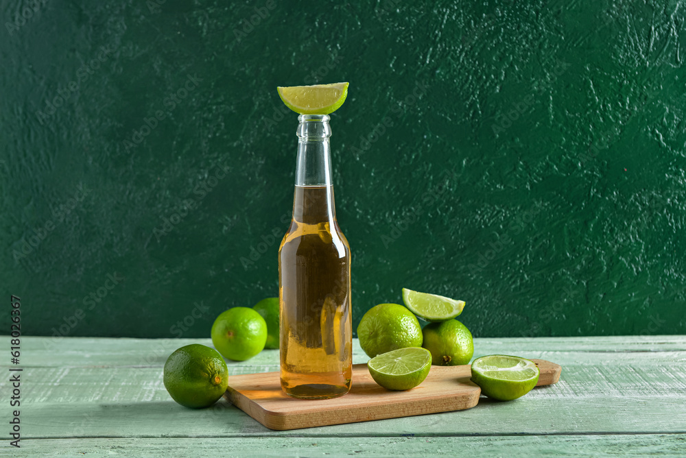 Bottle of cold beer with lime on table