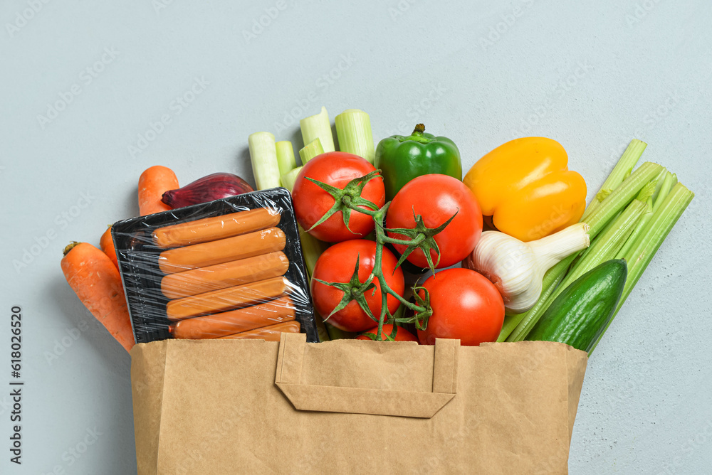 Paper bag with different products on grey background