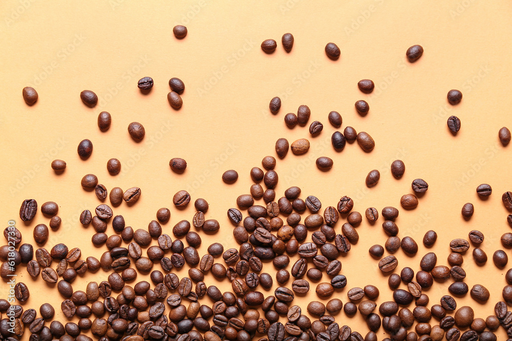 Scattered coffee beans on orange background