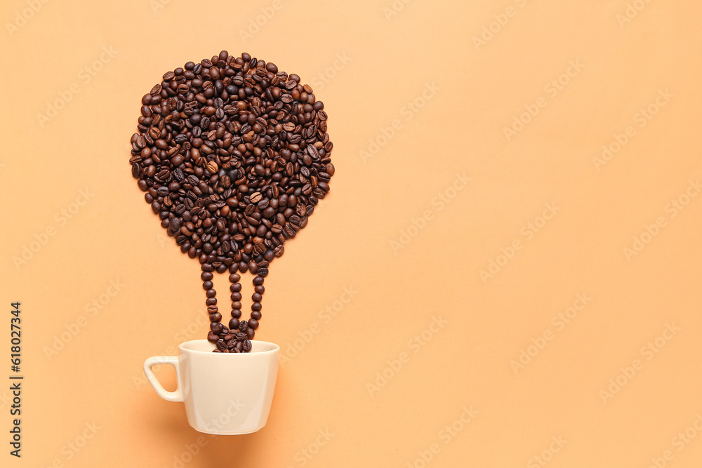 Coffee beans spilled from cup in shape of air balloon on orange background