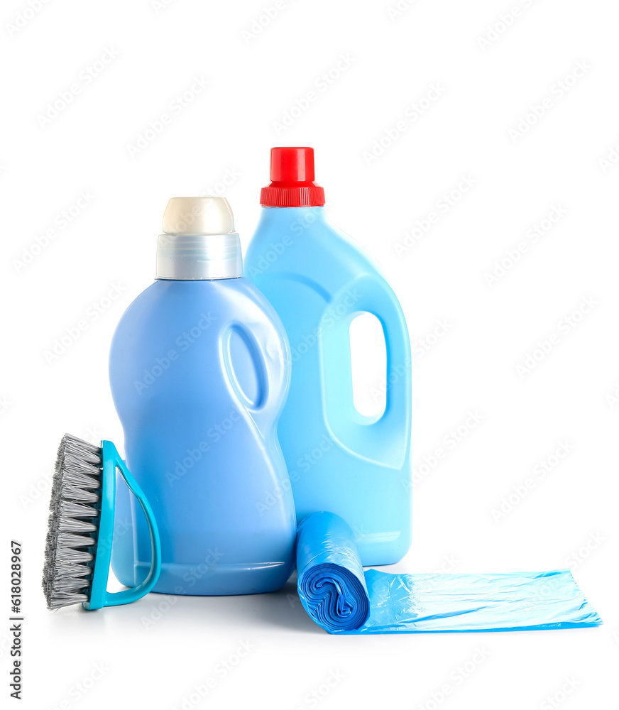 Bottles of detergent, brush and roll of garbage bags isolated on white background