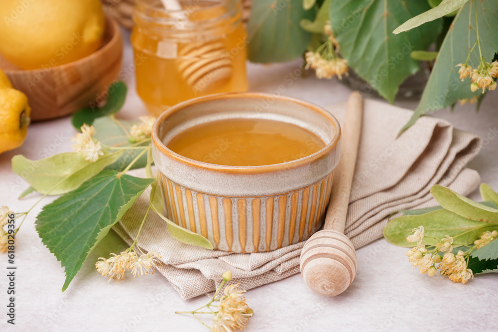 Bowl and jar with linden honey on white background