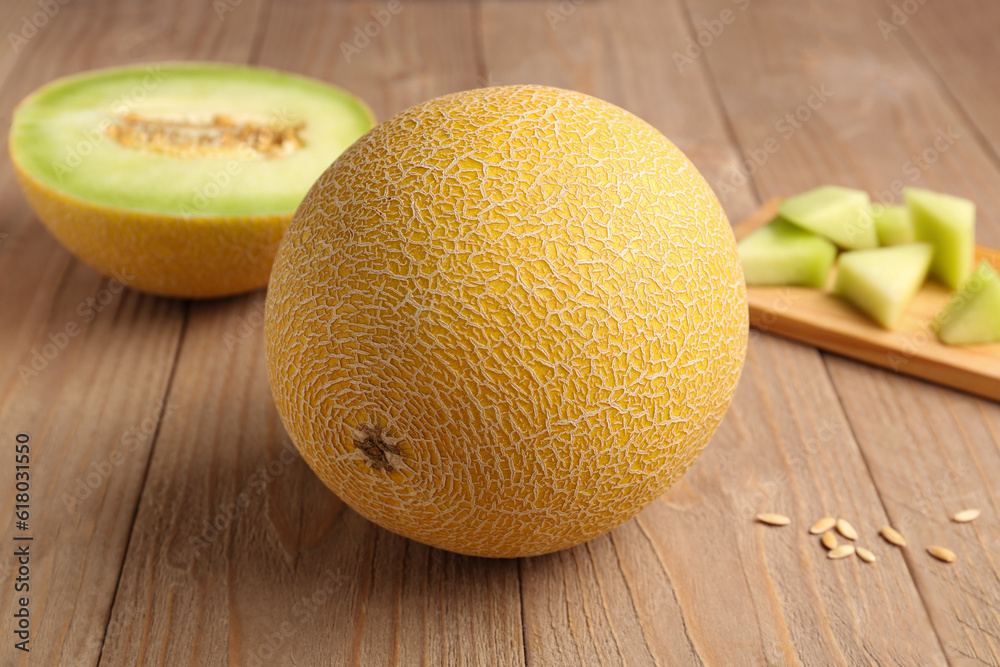 Sweet melon with half and seeds on wooden background