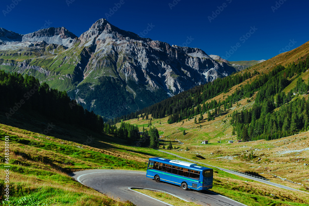 Passenger bus riding at Swiss Alps mountains in summer