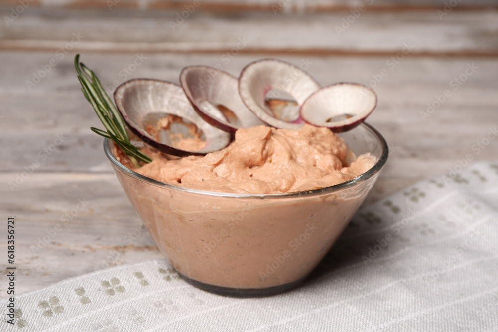 Bowl of delicious pate with onion on light wooden background