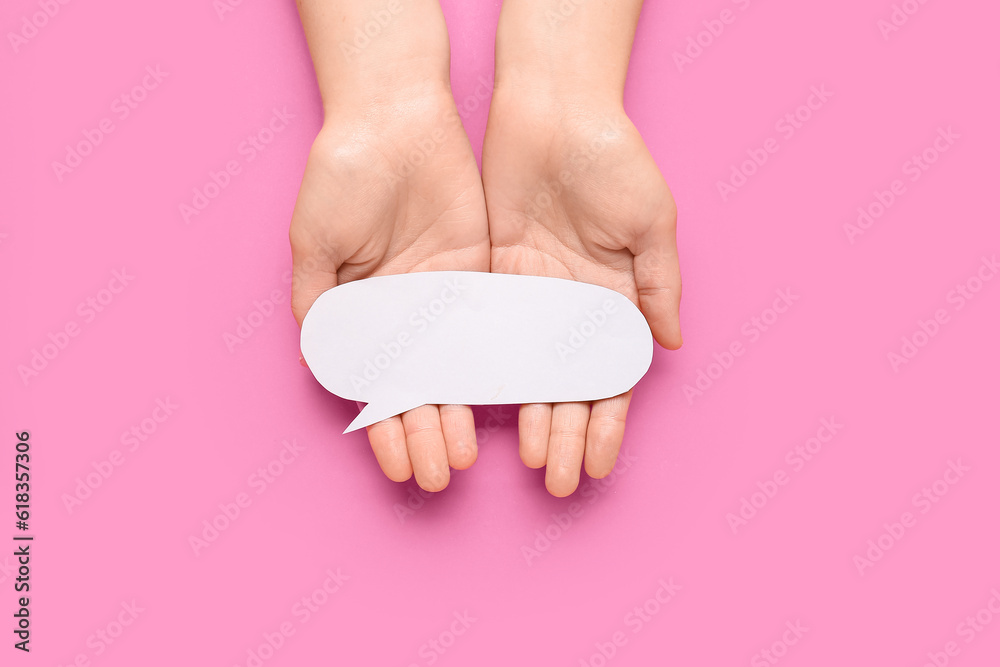 Woman holding blank speech bubble on pink background