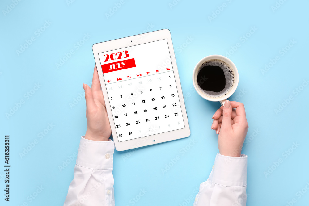 Woman holding tablet computer with calendar and cup of coffee on blue background