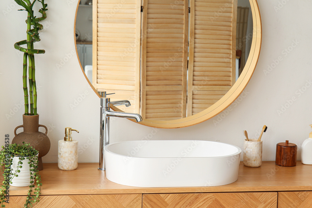 White sink with bath accessories on table in room