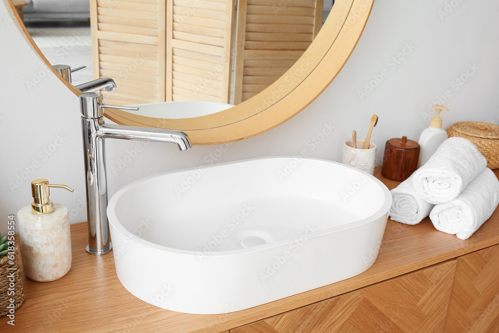 White sink with bath accessories on table in room