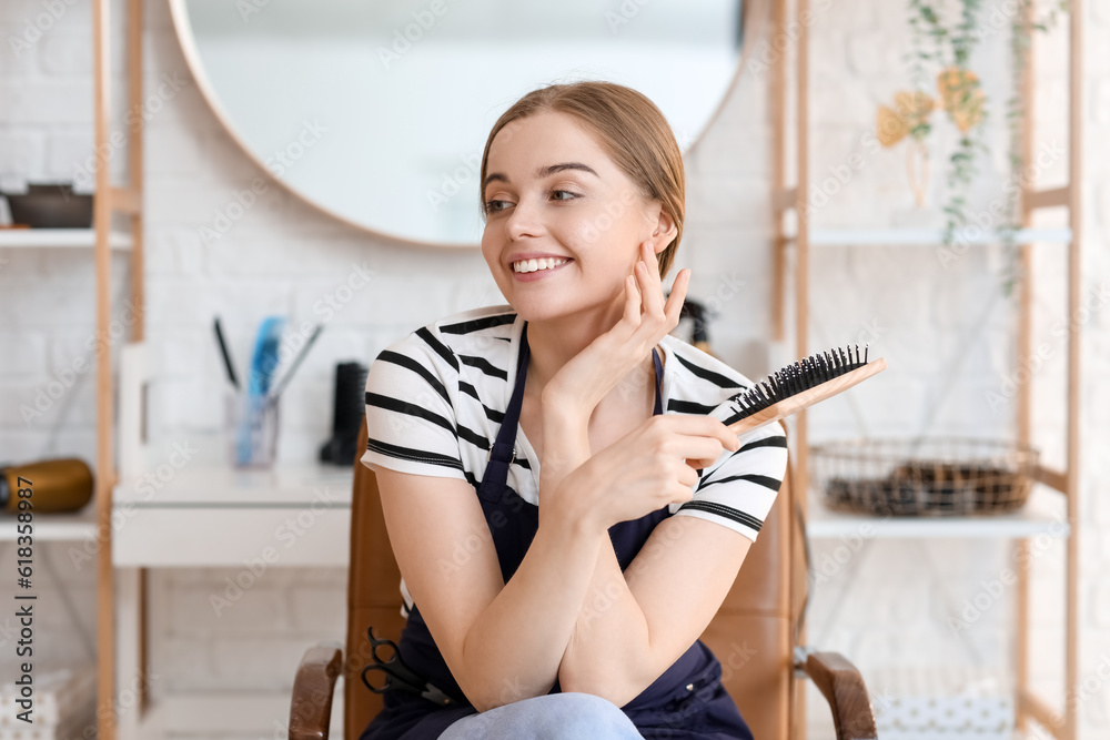 Female hairdresser with brush in beauty salon