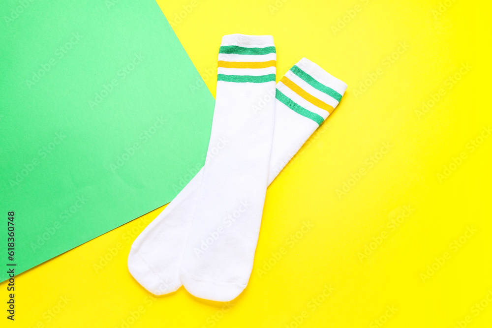 Pair of soft cotton socks on color background