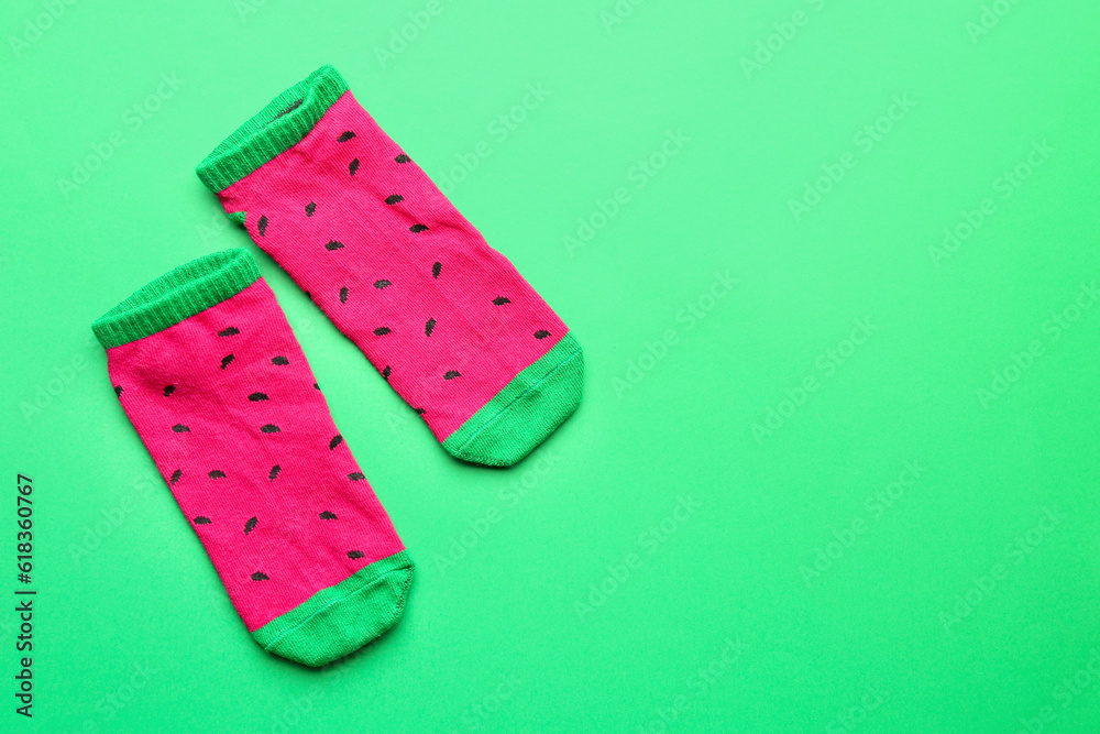 Pair of colorful cotton socks on green background