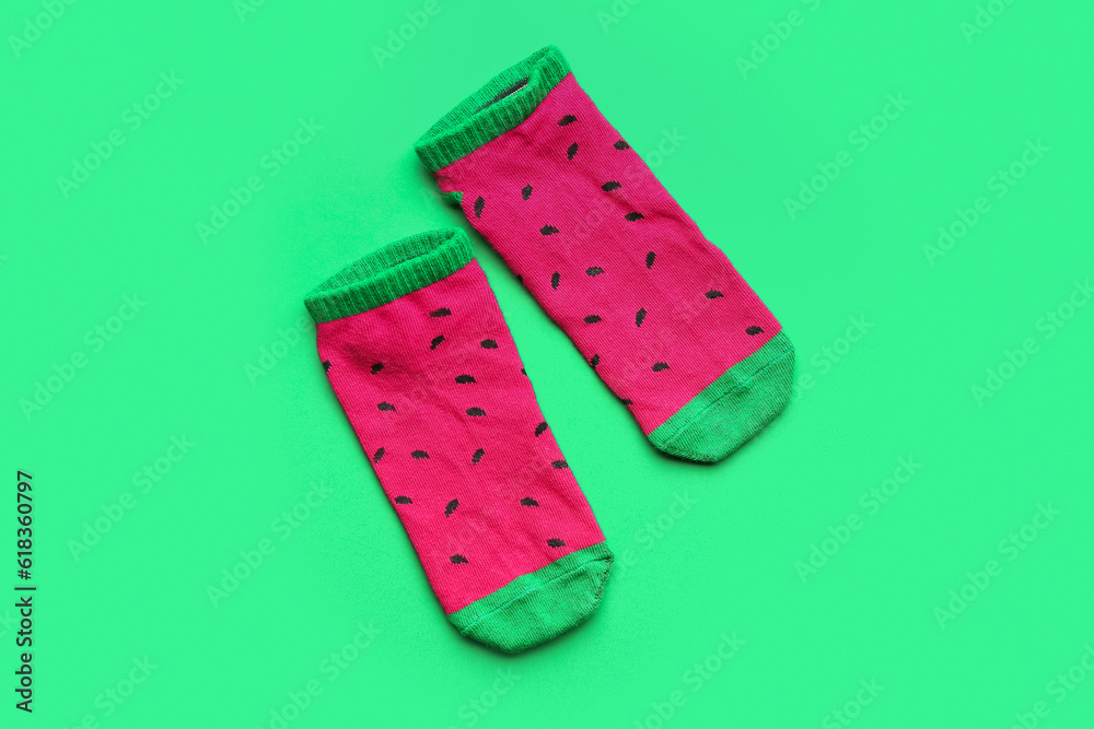 Pair of colorful cotton socks on green background