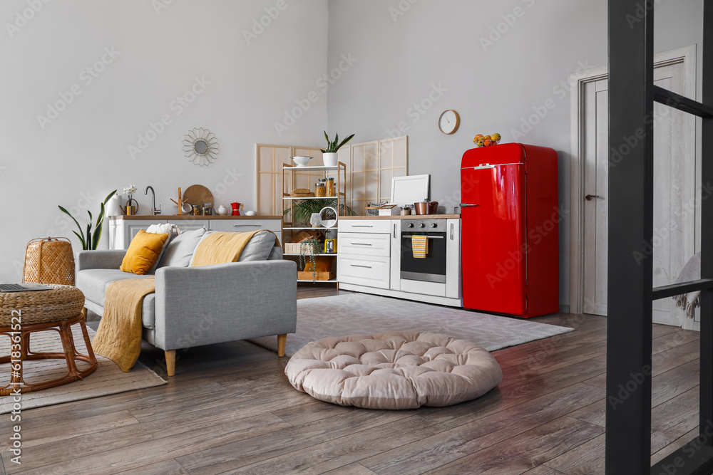 Interior of kitchen with red fridge, counters and sofa