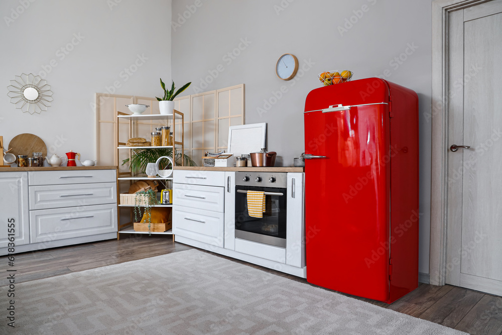 Interior of kitchen with red fridge, counters and shelving unit