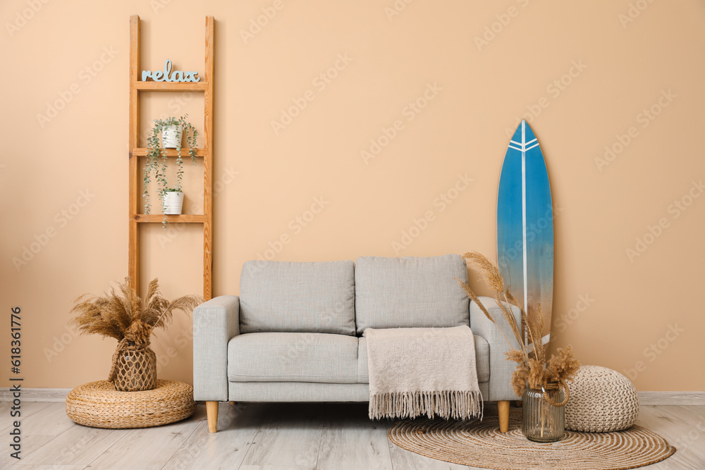 Interior of modern stylish room with surfboard, shelving unit and sofa