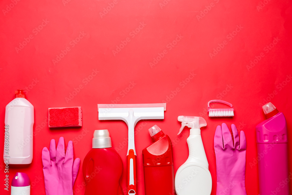 Different cleaning supplies on red background