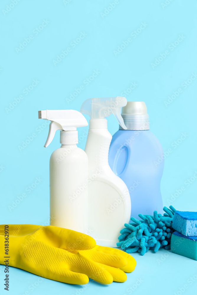 Different cleaning supplies on blue background