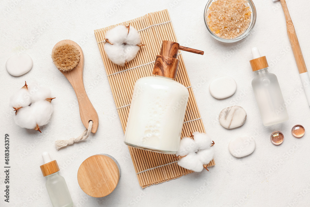 Composition with cosmetic products, bath supplies and cotton flowers on light background