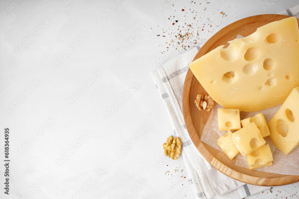 Plate with pieces of Swiss cheese and walnut on white background