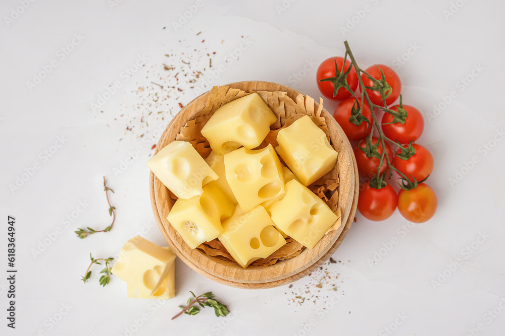 Bowl with pieces of Swiss cheese and tomatoes on white background