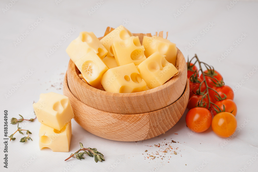 Bowl with pieces of Swiss cheese and tomatoes on white background