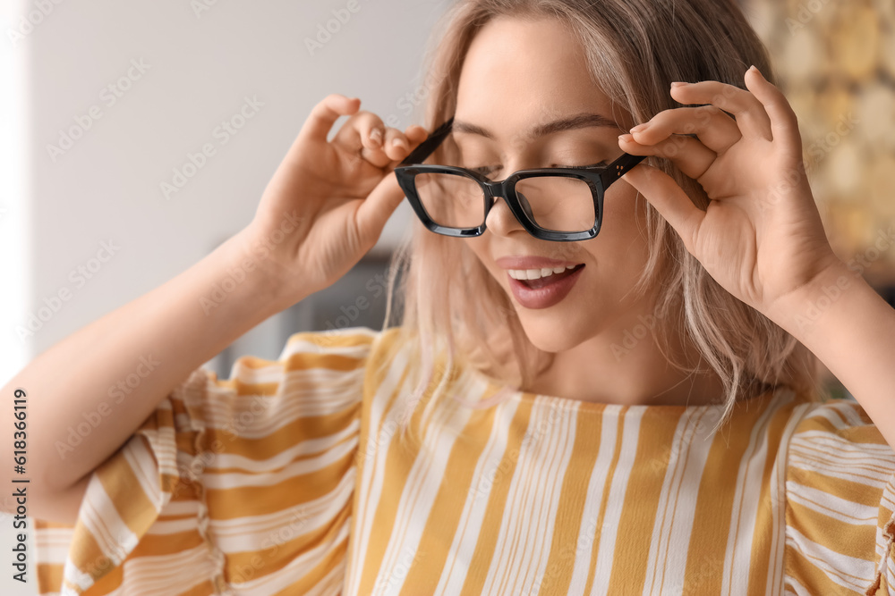 Young woman with stylish eyeglasses in office, closeup