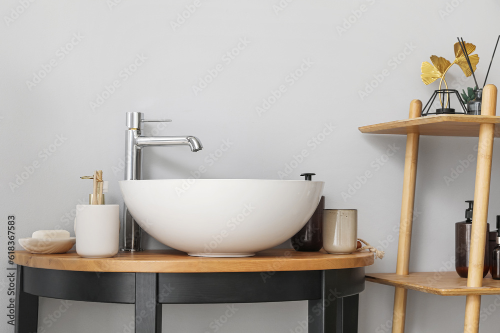 Sink bowl and bath accessories on table in bathroom, closeup