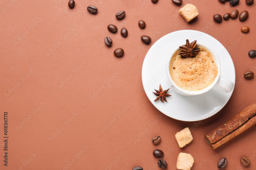 Cup of hot espresso and coffee beans on brown background