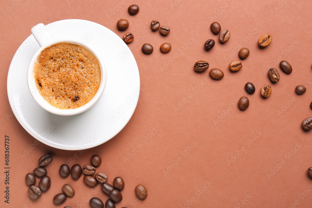 Frame made of coffee beans and cup with hot espresso on brown background