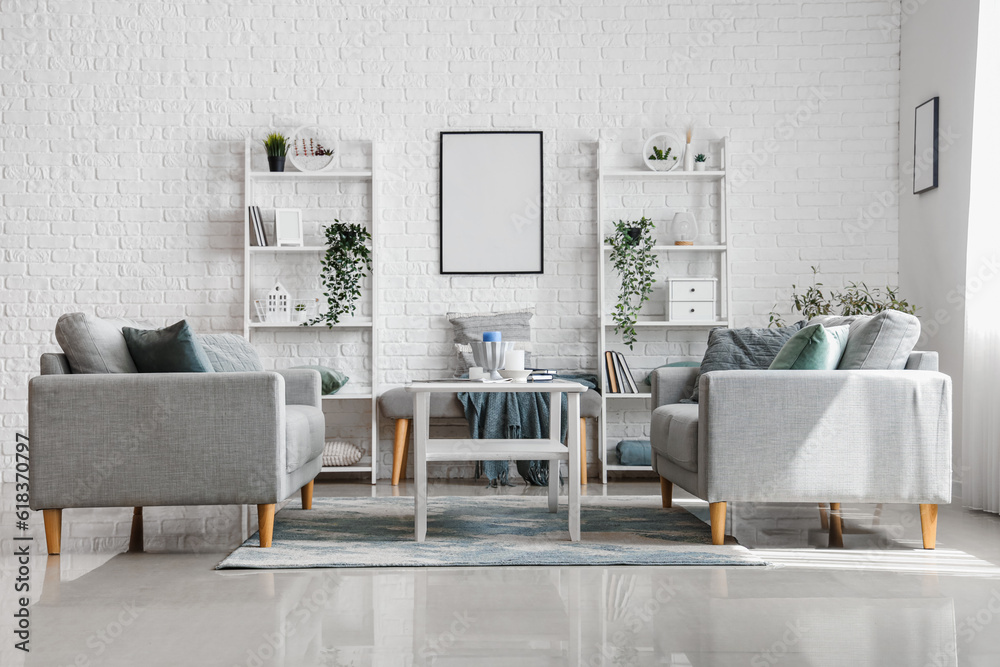 Interior of light living room with cozy grey sofas and coffee table