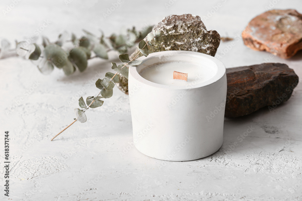 Holder with candle and stones on white background