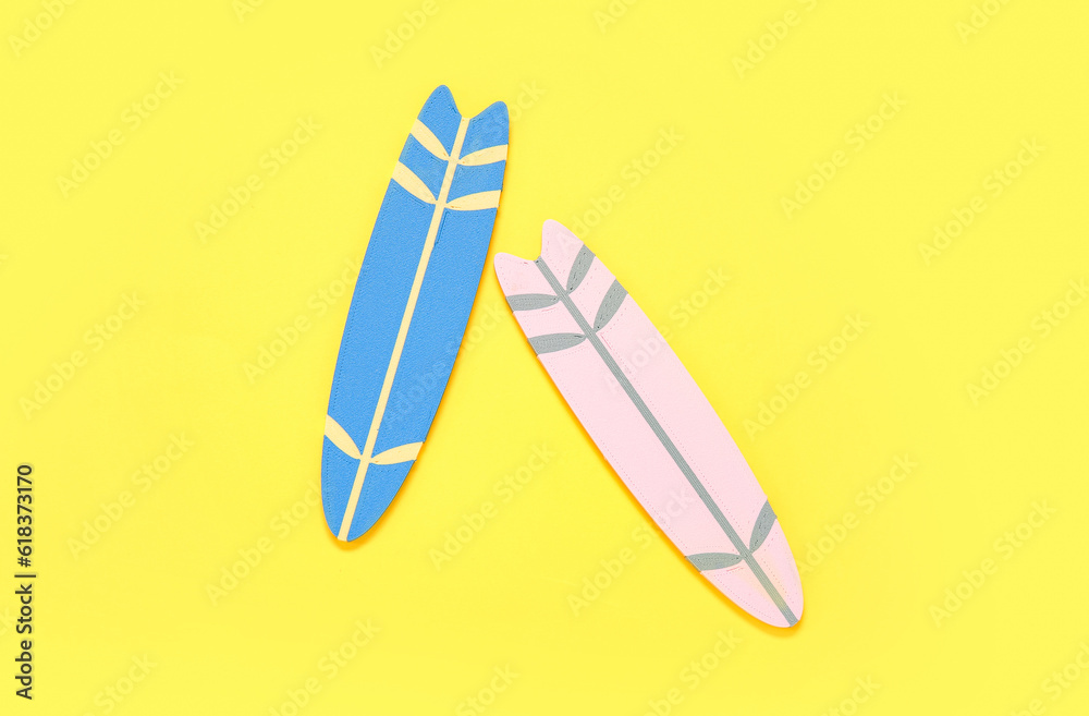 Mini colorful surfboards on yellow background