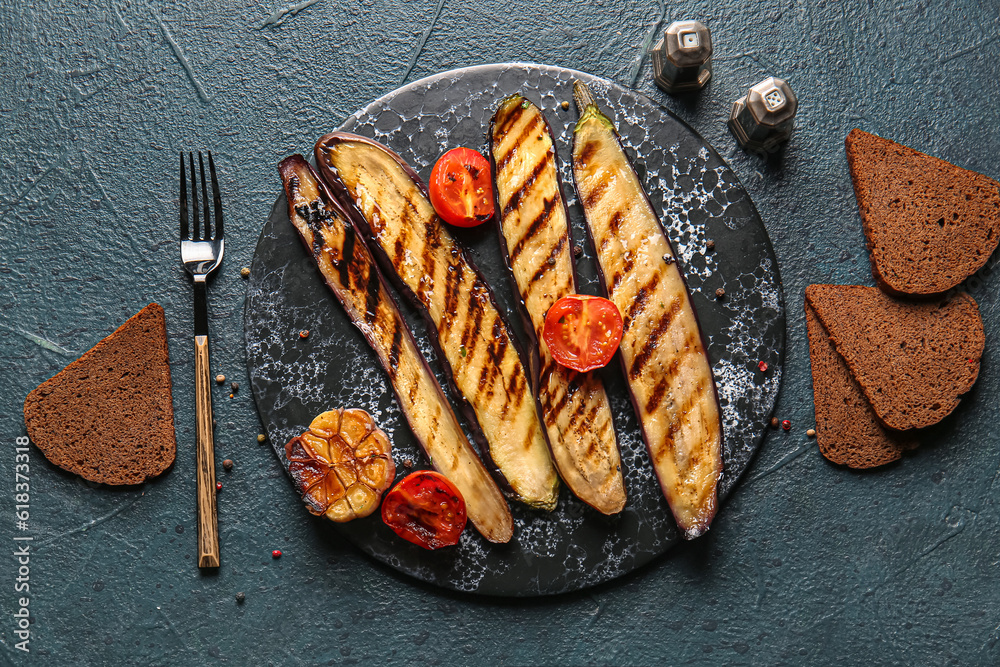 Delicious grilled eggplants and tomatoes on dark background