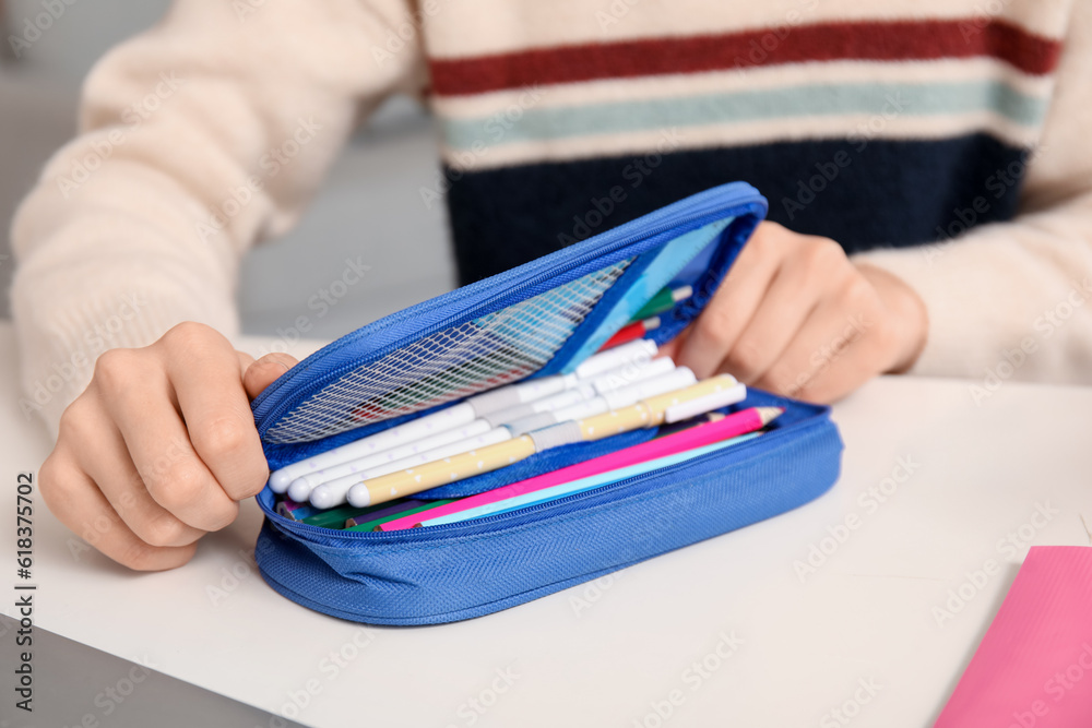 Female student with pencil case at table, closeup