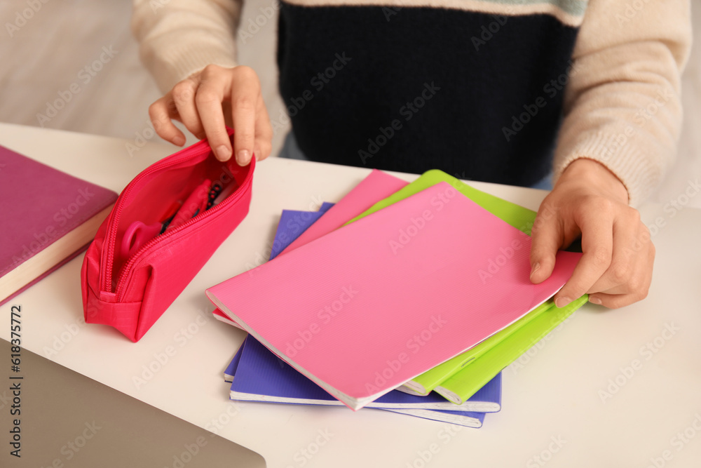 Female student with pencil case at table, closeup