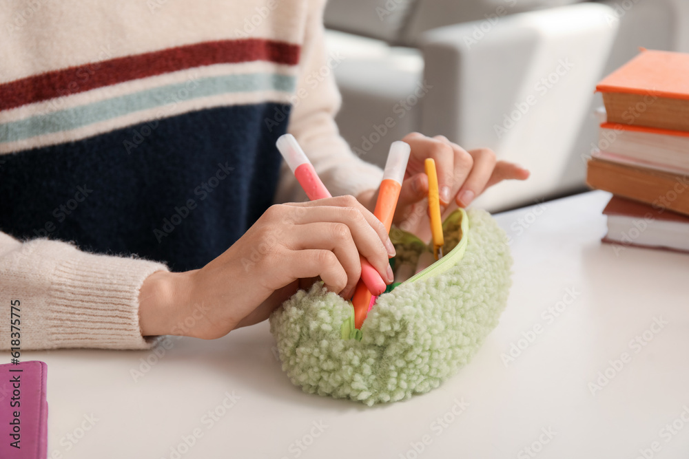 Female student with pencil case at table, closeup