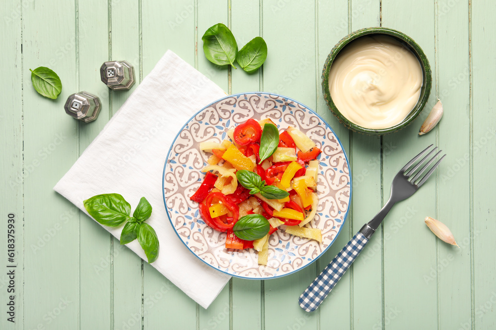 Plate with tasty grilled peppers and sauce on green wooden background