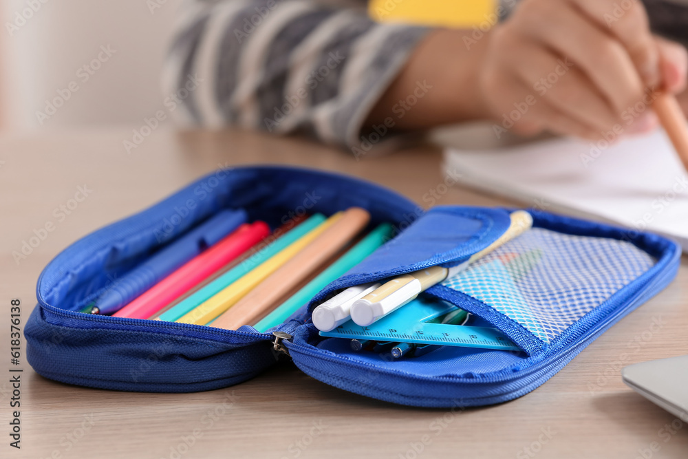 Open pencil case on table, closeup