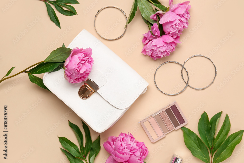 Composition with stylish female bag, bracelets, eyeshadows and beautiful peony flowers on color back