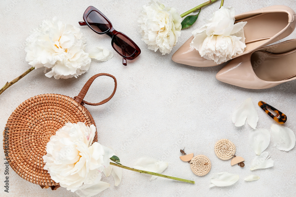 Frame made of stylish female accessories and beautiful peony flowers on light background