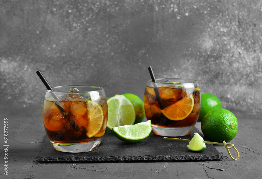 Glasses of cold Cuba Libre cocktail on grey background