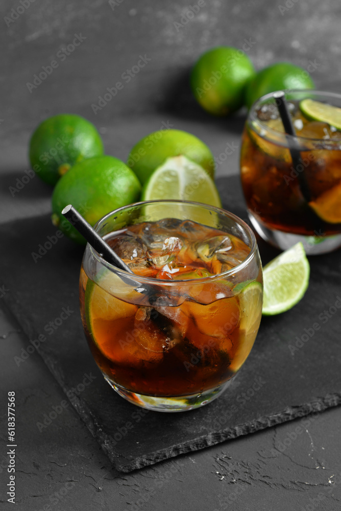 Glass of cold Cuba Libre cocktail on grey background