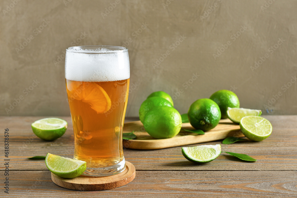 Glass of cold beer with lime on table