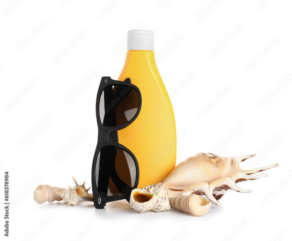 Sunglasses with bottle of sunscreen cream and seashells isolated on white background