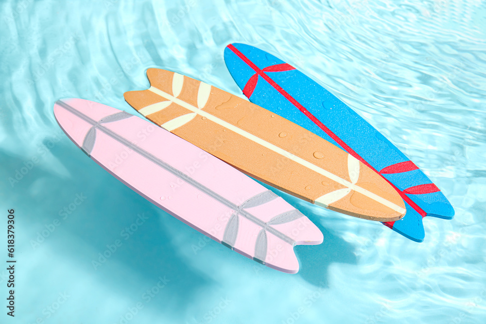 Different colorful mini surfboards in water