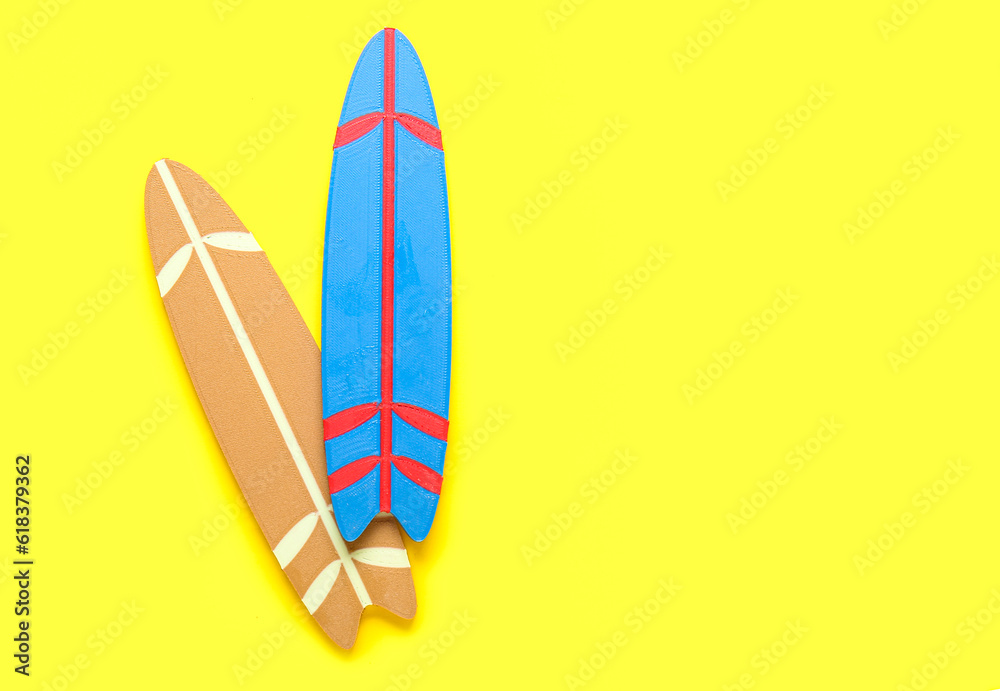 Mini different colorful surfboards on yellow background