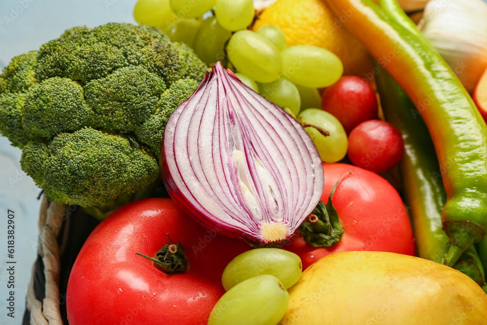 Wicker bowl with different fresh fruits and vegetables, closeup