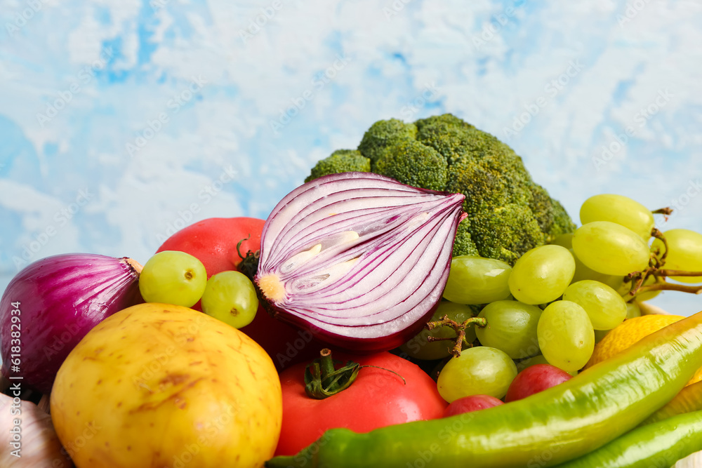 Different fresh fruits and vegetables on blue background, closeup