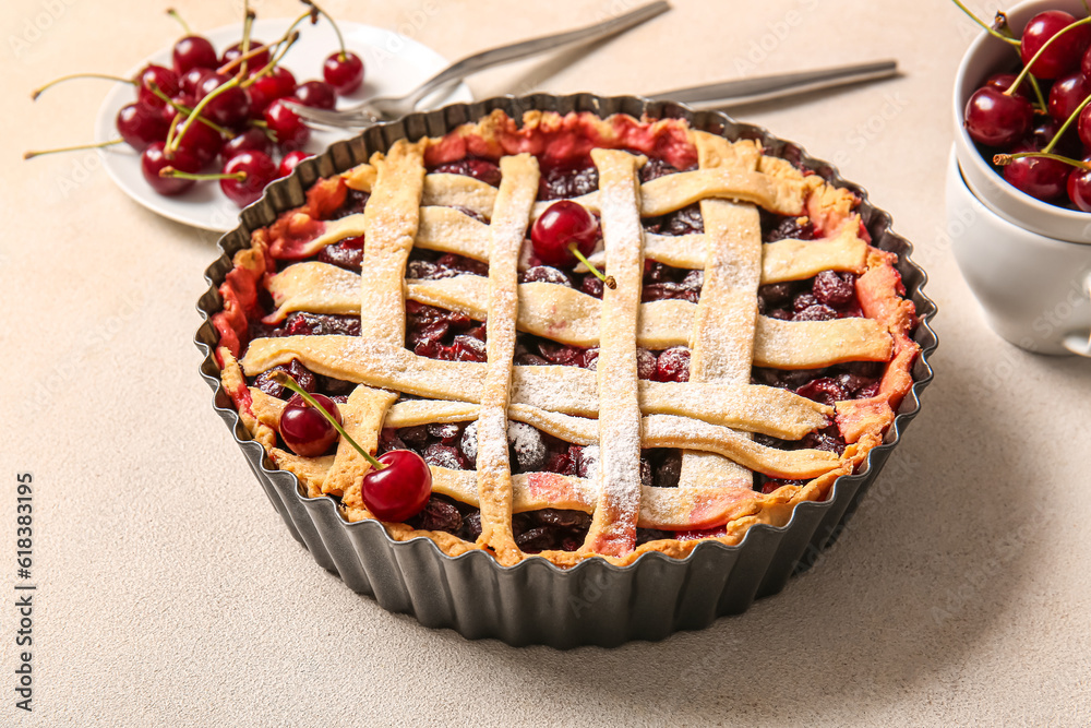 Baking dish with tasty cherry pie and plate of berries on white background